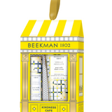 Beekman 1802 Kindness Cafe gift set in vanilla absolute containing three hand creams in a yellow and white storefront-themed box with a gold hanging loop. Available at Be Charmed
