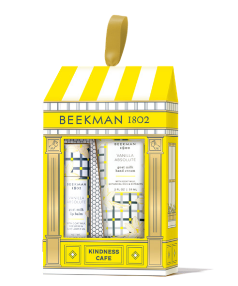 Beekman 1802 Kindness Cafe gift set in vanilla absolute containing three hand creams in a yellow and white storefront-themed box with a gold hanging loop. Available at Be Charmed