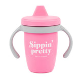 Bella Tunno Pink sippy cup with 'Sippin' pretty' text on a white background. Available at Be Charmed