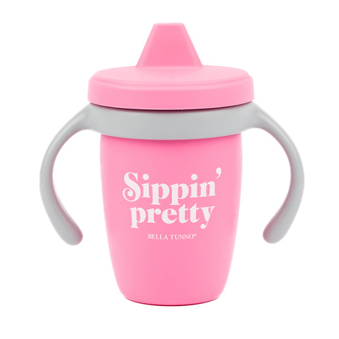 Bella Tunno Pink sippy cup with 'Sippin' pretty' text on a white background. Available at Be Charmed