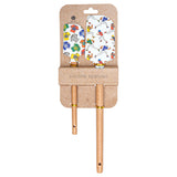 Two wooden-handled silicone spatulas with colorful footballl-themed silicone heads, displayed on a brown kraft cardboard hanger against a white background. Available at Be Charmed