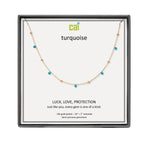 A CAI gold-plated necklace with small turquoise gemstones displayed on a branded white card inside a black presentation box. The card reads 'cai turquoise' and 'LUCK, LOVE, PROTECTION'. Available at Be Charmed
