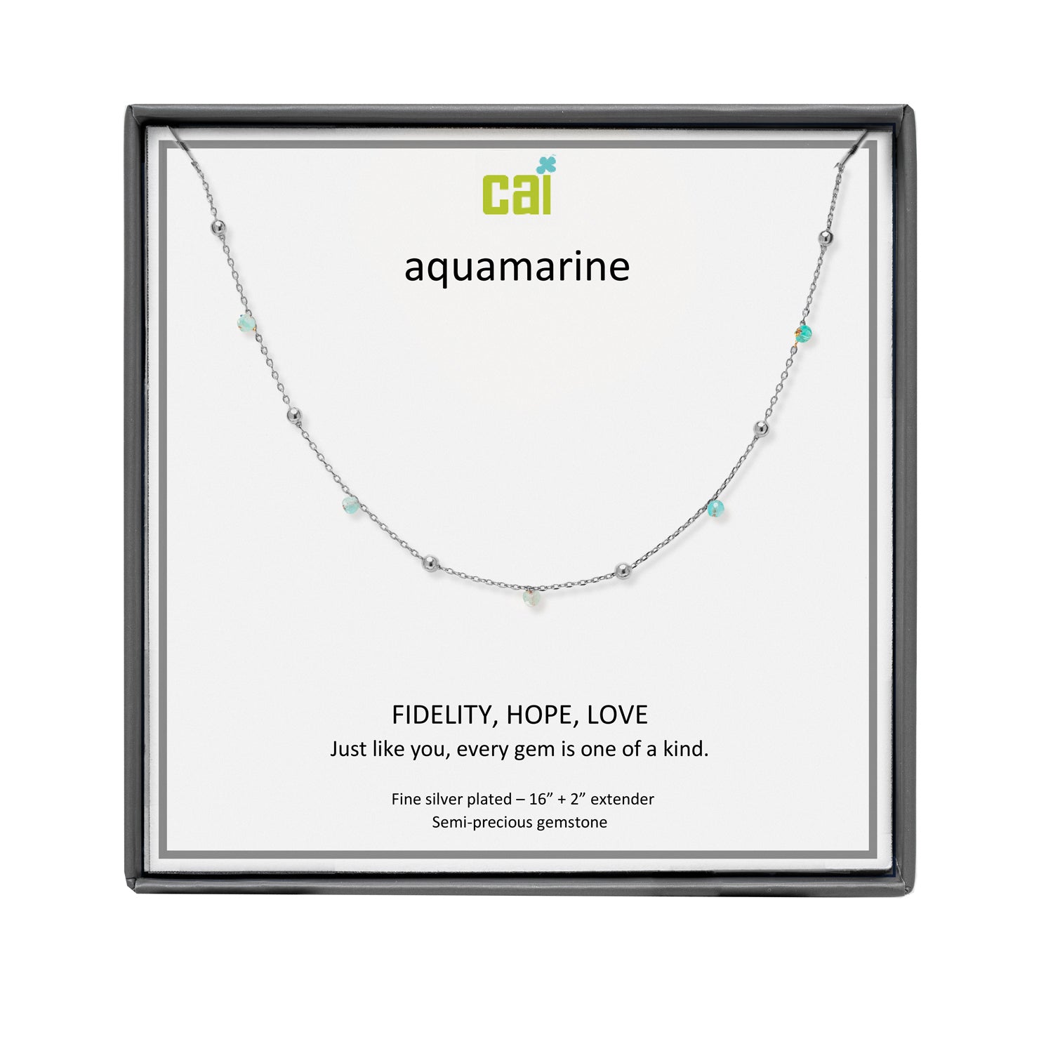 A CAI silver necklace with small aquamarine gemstones displayed on a white card inside a black square gift box. The card shows the brand name 'cai' and the word 'aquamarine' with additional product text below. Available at Be Charmed