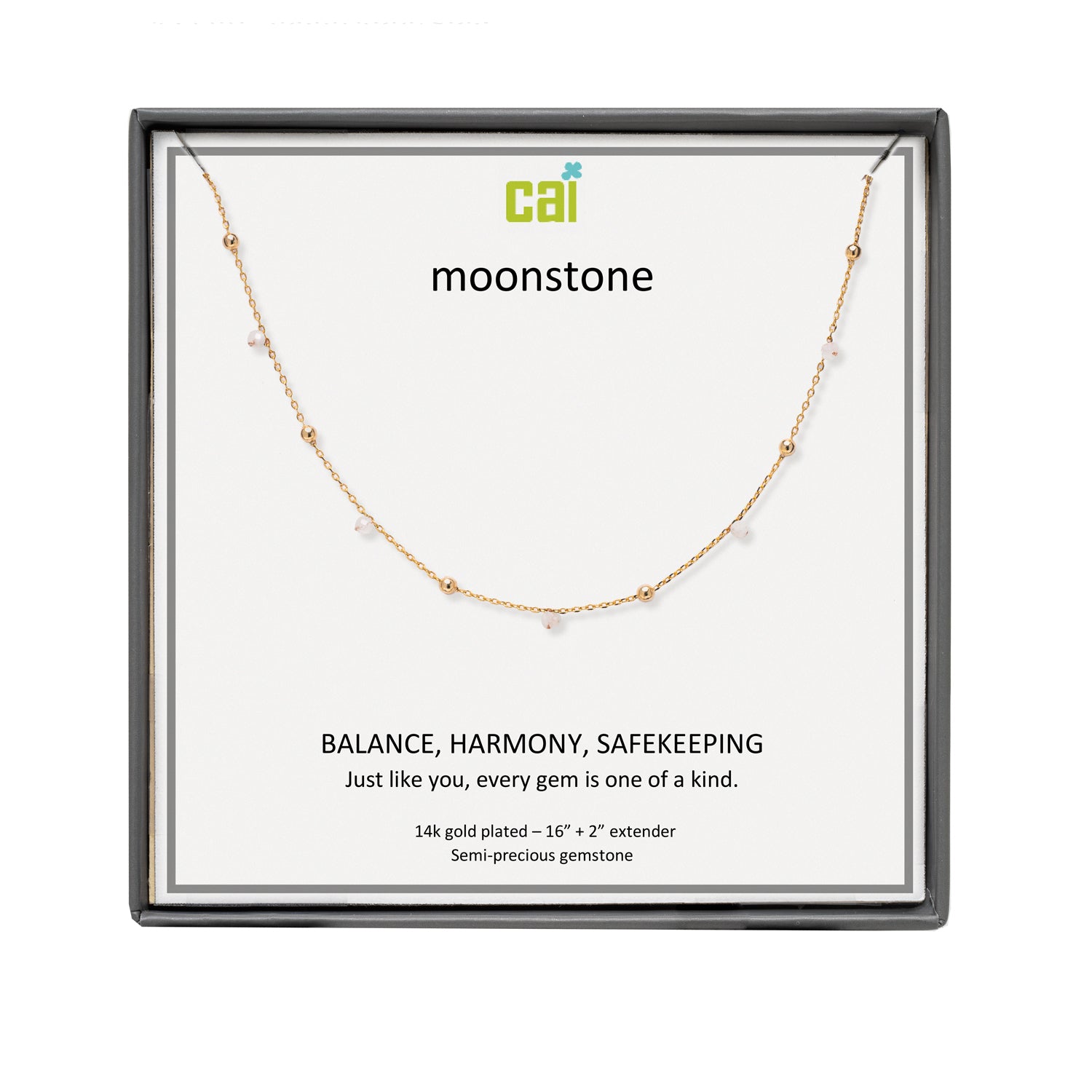 A CAI gold-plated necklace with small clear gemstones displayed on a white card inside a black square gift box. The card shows the brand name 'cai' and the product name 'moonstone'. Available at Be Charmed