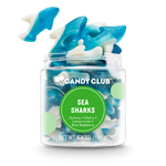 Jar of blue and white shark-shaped gummy candies with 'Candy Club' label on a white background. Available at Be Charmed