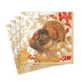 A stack of Caspari square paper napkins featuring a Thanksgiving turkey illustration with autumn leaves, berries, and a gold floral pattern on a white background. Available at Be Charmed