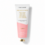 Chez Gagné 'You Are So Pretty' hand cream in a squeeze tube with a white and pink color-blocked design and gold lettering, set against a plain white background. Available at Be Charmed
