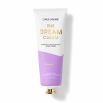 A squeeze tube of Chez Gagnée 'The Dream Cream' hand cream, featuring a white upper half with gold lettering and a lavender purple lower half, complete with a gold cap, set against a clean white background with a soft shadow. Available at Be Charmed