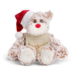A plush teddy bear gift toy with shaggy beige and white fur, wearing a red and white Santa hat and holding a small gold key charm attached to a message card, photographed on a clean white background. Available at Be Charmed