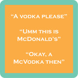 A square Drinks on Me coasterwith rounded corners featuring a peach-orange center panel with white text reading three lines: “A VODKA PLEASE,” “UMM THIS IS MCDONALD’S,” and “OKAY, A MCVODKA THEN.” The panel is surrounded by a mint-green border. Available at Be Charmed