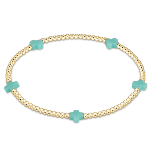 enewton gold-filled elastic bracelet with small mint green beads, featuring a signature cross design. Available at Be Charmed