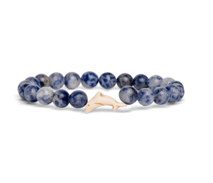 A beaded stretch Fahlo bracelet featuring round blue and white marbled beads with a small, smooth off-white dolphin charm, displayed on a clean white background. Available at Be Charmed