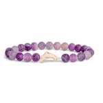 A beaded stretch Fahlo bracelet made of round purple and lavender marbled beads with a small light beige Dolpin charm, shown on a plain white background. Available at Be Charmed