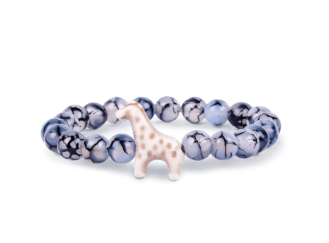 A beaded stretch Fahlo bracelet featuring glossy marbled blue, gray, and white beads with a small white giraffe charm set against a plain white background. Available at Be Charmed