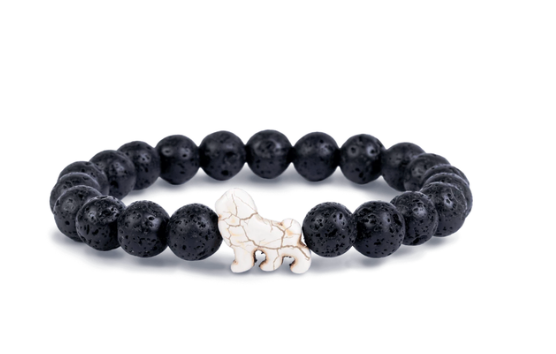 A beaded stretch Fahlo bracelet made of black porous lava stones with a small white lion charm in the center, shown on a plain white background. Available at Be Charmed
