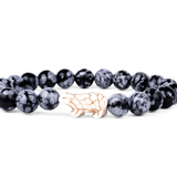 A beaded stretch fahlo bracelet featuring round black and white marbled beads with a central light beige polar bear charm, displayed on a clean white background. Available at Be Charmed