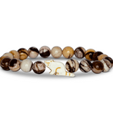 A beaded stretch Fahlo bracelet featuring marbled brown, cream, and white beads, with a red panda charm, displayed on a clean white background. Available at Be Charmed