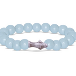 A beaded bracelet made of Aqua glow round beads with a central marbled shoark charm, shown on a plain white background. Available at Be Charmed