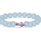 A beaded bracelet made of Aqua glow round beads with a central marbled shoark charm, shown on a plain white background. Available at Be Charmed
