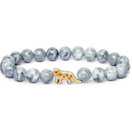 A beaded stretch Fahlo bracelet featuring light blue and white marbled round beads with a small central snow leopared charm, displayed on a clean white background. Available at Be Charmed
