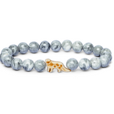 A beaded stretch Fahlo bracelet featuring light blue and white marbled round beads with a small central snow leopared charm, displayed on a clean white background. Available at Be Charmed
