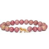 A beaded stretch Fahlo bracelet featuring round pinkish-red beads with one snow leopard charm, displayed on a clean white background. Available at Be Charmed