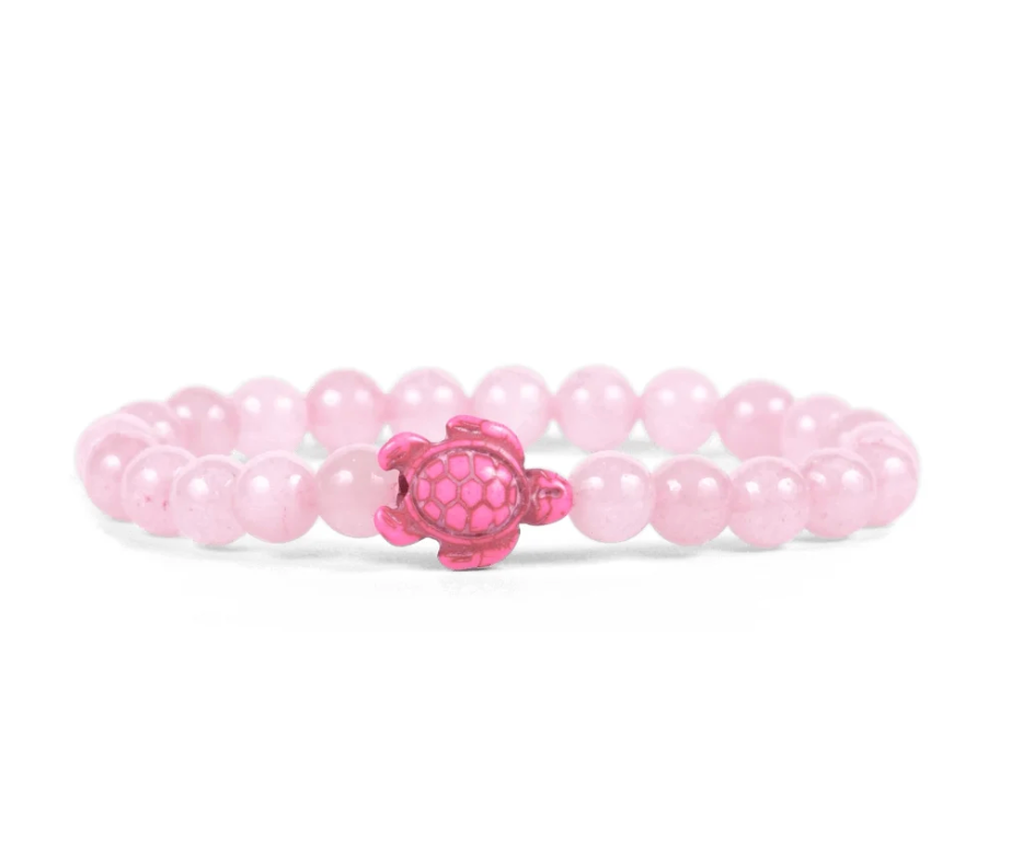 A pink beaded Fahlo bracelet with a small pink turtle charm at the center, displayed on a clean white background. Available at Be Charmed