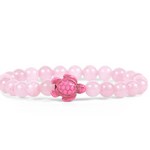 A pink beaded Fahlo bracelet with a small pink turtle charm at the center, displayed on a clean white background. Available at Be Charmed