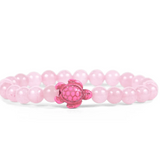 A pink beaded Fahlo bracelet with a small pink turtle charm at the center, displayed on a clean white background. Available at Be Charmed