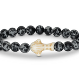 A beaded stretch Fahlo bracelet featuring round black and white mottled beads with a central off-white whale shark, shown on a plain white background. Available at Be Charmed