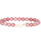 A pink beaded Fahlo bracelet with round pink stone beads and a small white whale-shaped charm, shown on a plain white background. Available at Be Charmed