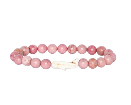 A pink beaded Fahlo bracelet with round pink stone beads and a small white whale-shaped charm, shown on a plain white background. Available at Be Charmed