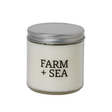 Farm + Sea Cranberry Bog 14 oz candle featuring a clear glass jar and festive seasonal label available at Be Charmed