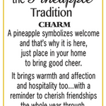 A white card with a thin yellow border, featuring black text that reads 'the Pineapple Tradition CHARM' and a quote about pineapple symbolism and warmth, signed '-a.s. Available at Be Charmed