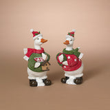 Two decorative duckf igurines dressed in holiday sweaters and Santa hats, standing side by side on a plain beige studio background. Available at Be Charmed
