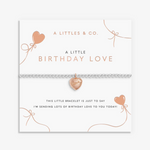 A littletes & Co. rose gold bracelet with a heart-shaped charm, displayed on its white gift card with birthday-themed text and illustrations. Available at Be Charmed