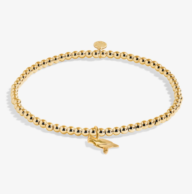 A Littles & Co Christmas Cardinal gold bracelet featuring a delicate cardinal charm on a beaded band, available at Be Charmed