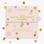 A silver-toned bracelet with a gold heart charm and rhinestone trim, presented on a pale pink card that reads 'A LITTLE HAPPY BIRTHDAY FRIEND.' The card is surrounded by pink and gold confetti on a white background. Available at Be Charmed