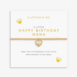 A gold heart-themed bracelet by A Littles & Co. displayed on its white gift card, which reads 'A LITTLE HAPPY BIRTHDAY NANA'. Available at Be Charmed