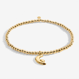 A Littles & Co Little Love You To The Moon And Back gold bracelet featuring a delicate crescent moon charm on a beaded band, available at Be Charmed