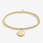 A Littles & Co Love You More gold bracelet featuring a delicate gold charm on a beaded band, available at Be Charmed