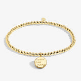 A Littles & Co Love You More gold bracelet featuring a delicate gold charm on a beaded band, available at Be Charmed