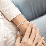 A Littles & Co Love You To The Moon And Back bracelet featuring a delicate moon and star charm on a beaded band, available at Be Charmed