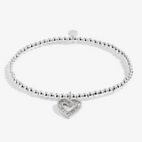 A Littles & Co Merry Christmas silver bracelet featuring a delicate silver holiday charm on a beaded band, available at Be Charmed