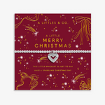 A silver heart charm bracelet with clear rhinestone accents, presented on a festive red and gold Christmas greeting card by A Littlees & Co. Available at Be Charmed