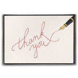 A boxed set of thank you cards with cursive writing on the front, accompanied by a cream envelope, presented in a clear slip cover. Available at Be Charmed