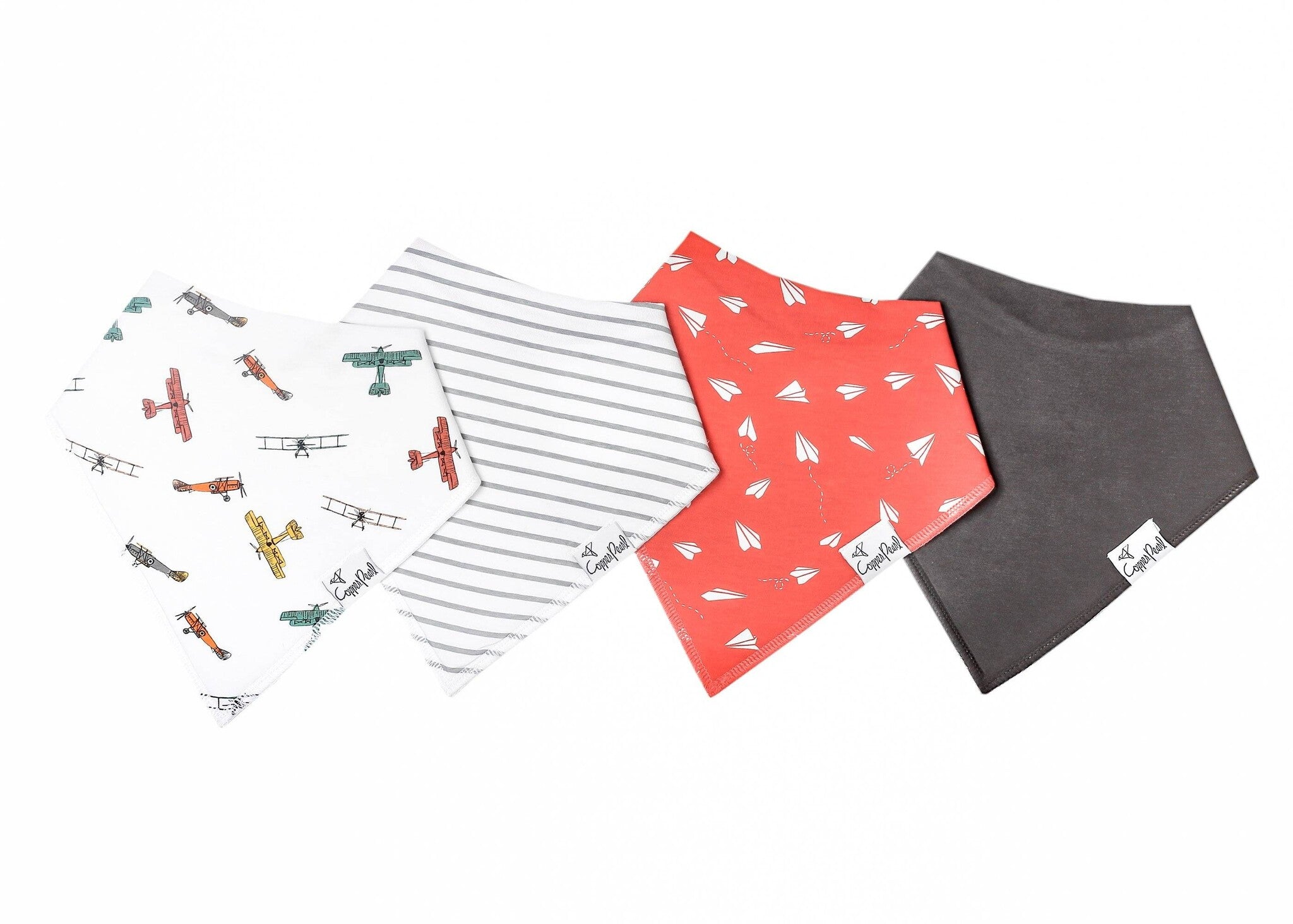 A set of four folded baby bibs with various patterns including an airplane, stripes, and solid colors. Available at Be Charmed