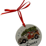 A round, decorative Christmas ornament featuring Santa Claus in a woodie vehicle with 'Dover' written on it, hanging from a red ribbon. Available at Be Charmed