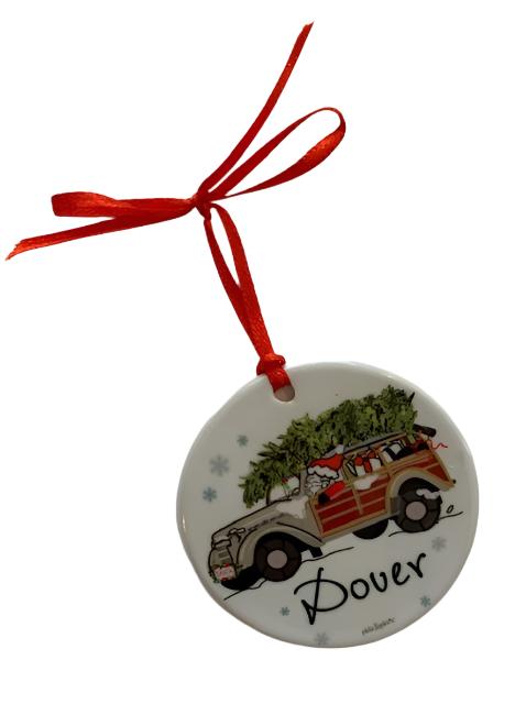 A round, decorative Christmas ornament featuring Santa Claus in a woodie vehicle with 'Dover' written on it, hanging from a red ribbon. Available at Be Charmed