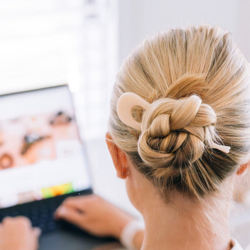 Person with a stylish hair bun using a Teleties french pin.
